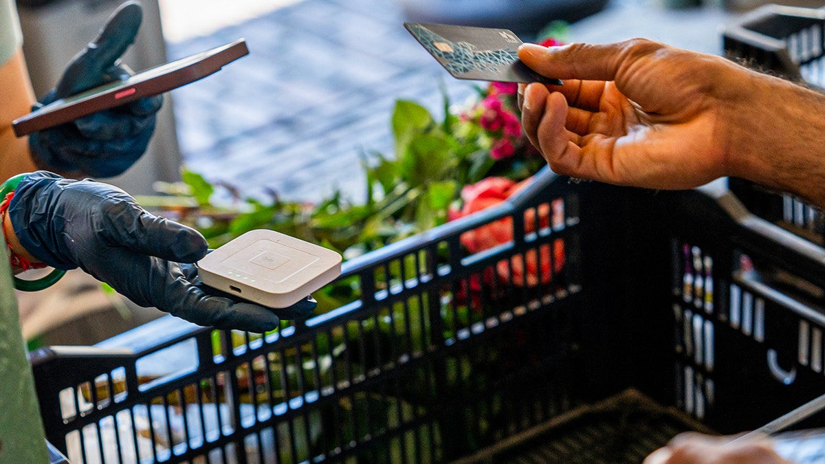 Woman tapping her credit card at the groceries.
