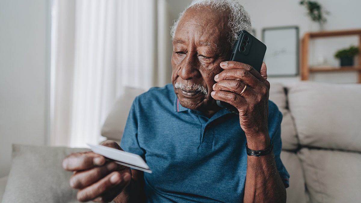Elderly man using smarphone and credit card